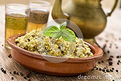 Couscous with vegetables and tea on a rustic wooden table Stock Photo