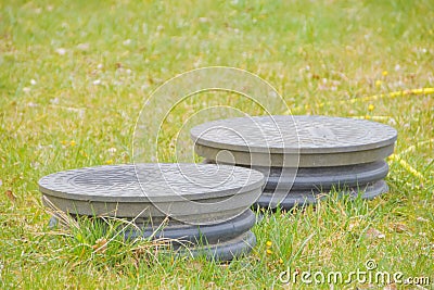 Cover sewer in the grass on the garden plot Stock Photo