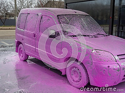 Covered auto with pink foam at a self-service car wash Stock Photo