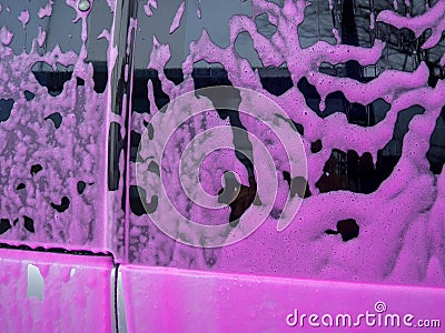 Covered auto with pink foam at a self-service car wash Stock Photo