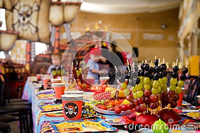 Covered festive table in pirate symbolism with food on a pirate party Stock Photo