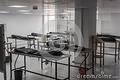 Covered human corpses on tables in a morgue / mortuary waiting for identification, autopsy, burial or cremation. Taken in Armenia Stock Photo