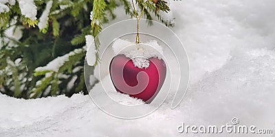 Covered with white snow, New Year`s Christmas decorations in the shape of a heart: a gift for the winter holiday - Valentine`s Day Stock Photo