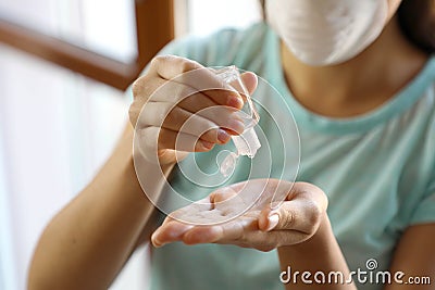 COVID-19 Close up woman hands using wash hand sanitizer gel dispenser, against Novel 2019-nCoV at home. Home Stock Photo