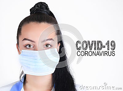 Covid-19 coronavirus desease global pandemic outbreak. A young female doctor in a medical mask with lettering. Close up portrait f Stock Photo