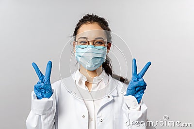 Covid19, coronavirus, healthcare and doctors concept. Portrait of optimistic asian female doctor ask to stay safe, wear Stock Photo