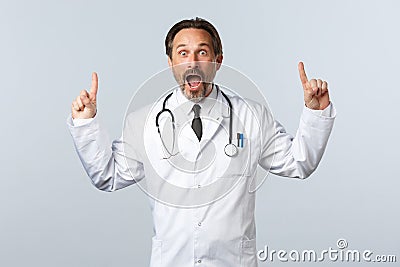 Covid-19, coronavirus outbreak, healthcare workers and pandemic concept. Startled excited doctor in white coat and Stock Photo