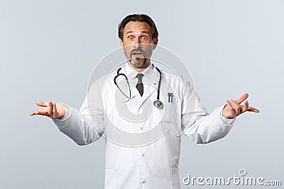 Covid-19, coronavirus outbreak, healthcare workers and pandemic concept. Worried indecisive male doctor in white coat Stock Photo