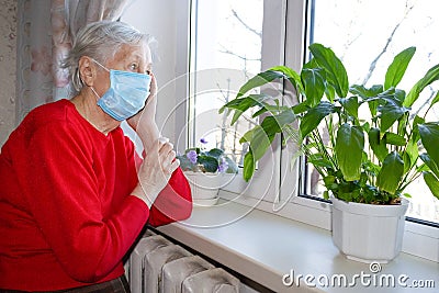 The Covid-19, health, safety and pandemic concept - senior old lonely woman sitting near the window Stock Photo