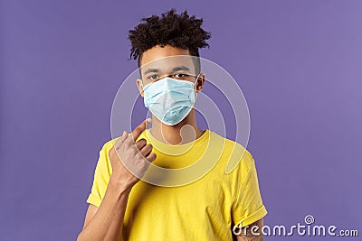 Covid19, healthcare and medicine concept. Young hispanic guy with afro haircut, wear and point at face mask, social Stock Photo