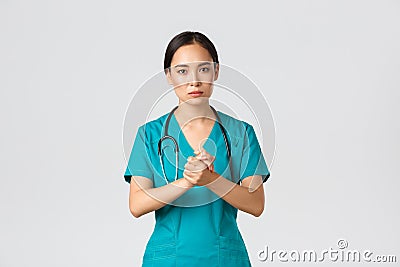 Covid-19, healthcare workers, pandemic concept. Hopeful serious-looking asian nurse, doctor asking something with Stock Photo