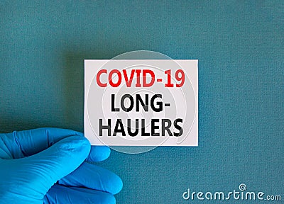 COVID-19 long-haulers covid symptoms symbol. White card with words Covid-19 long-haulers. Doctor hand, blue background, copy space Stock Photo