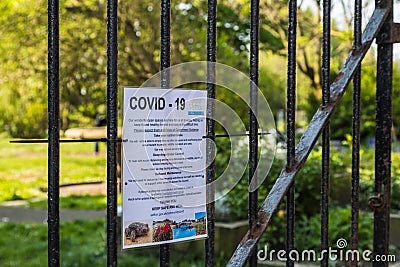 Covid 19 notice on the gates to a park Editorial Stock Photo