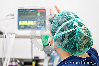 Covid-19 outbreak. Healthcare worker. Nurse working in intensive care unit. Mechanical ventilation system in the Stock Photo