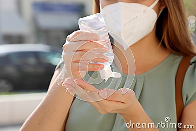 COVID-19 Pandemic Coronavirus Close up Unidentified Woman with KN95 FFP2 Mask using Alcohol Gel Sanitizer Hands in City Street. Stock Photo
