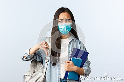 Covid-19 pandemic, education during coronavirus, back to school concept. Upset and disappointed freshman student in Stock Photo