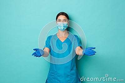 Covid-19, pandemic and medicine concept. Caring beautiful female doctor in medical mask, gloves and scrubs, reaching Stock Photo