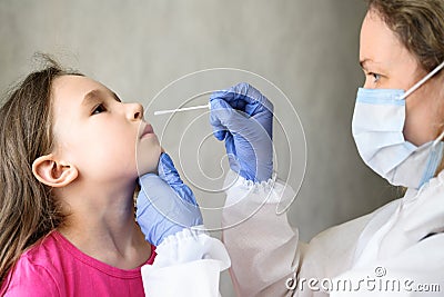 COVID-19 PCR test and kid, nurse holds swab for nasal sample from adorable child Stock Photo