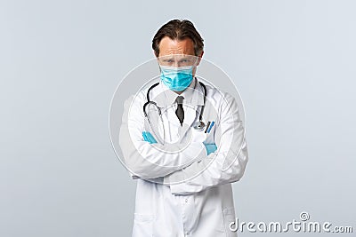 Covid-19, preventing virus, healthcare workers and vaccination concept. Offended timid doctor in medical mask and gloves Stock Photo