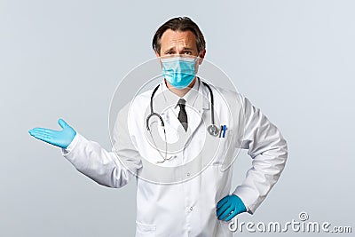 Covid-19, preventing virus, healthcare workers and vaccination concept. Skeptical and confused male doctor in medical Stock Photo