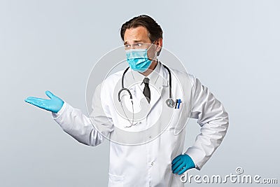 Covid-19, preventing virus, healthcare workers and vaccination concept. Skeptical disappointed doctor in medical mask Stock Photo