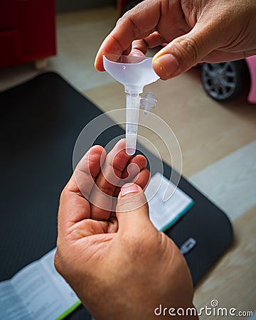 Covid rapid home-use test kit for saliva - step 2 - saliva liquid of ampoule in plastic tube Editorial Stock Photo