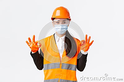Covid-19 safety protocol at enterpise, construction and preventing virus concept. Satisfied asian female engineer Stock Photo