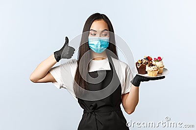 Covid-19, social distancing, small coffee shop business and preventing virus concept. Smiling asian bakery owner, female Stock Photo