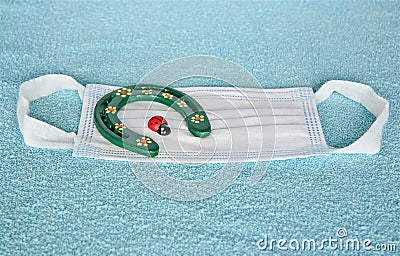 Covid-19, surgical mask, typical 3-ply to cover the mouth and nose with lucky charms ladybird and horseshoe Stock Photo