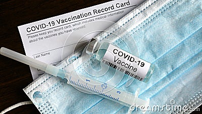 COVID-19 vaccine bottle, syringe, surgical mask and coronavirus Vaccination Record Card Stock Photo