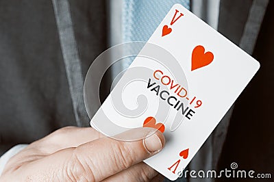 Covid-19 vaccine concept: a man in suit and tie show a playing card with the text covid-19 vaccine Stock Photo