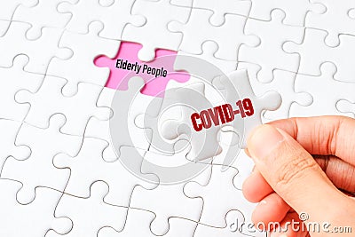 The COVID-19 word on white jigsaw puzzle go to replace elderly people word on purple gap - idea answer concept Stock Photo