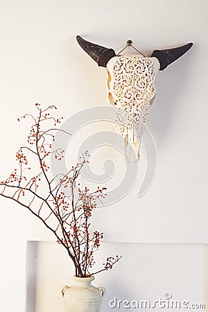 Cow bull head and dried berry flowers home decor on white wall Stock Photo