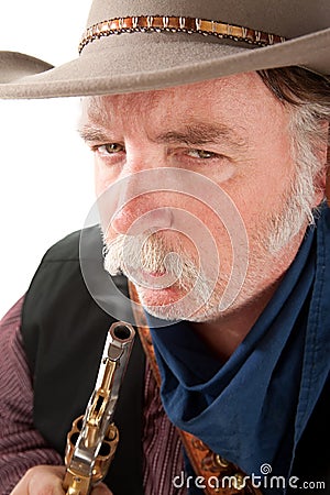 Cowboy blowing on the end of a hot pistol Stock Photo