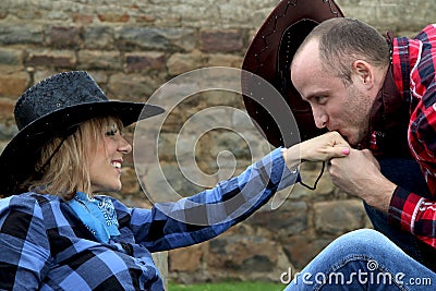 Cowboy kissing hand of cowgirl Stock Photo