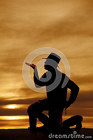 Cowboy kneel silhouette blow kiss Stock Photo