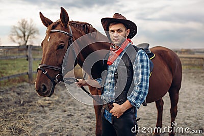 Cowboy poses with horse on texas farm Stock Photo