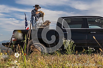 Cowboy Rancher Preparing Ropes on Back of His Pickup Truck Stock Photo