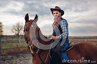 Cowboy riding a horse on texas farm Stock Photo