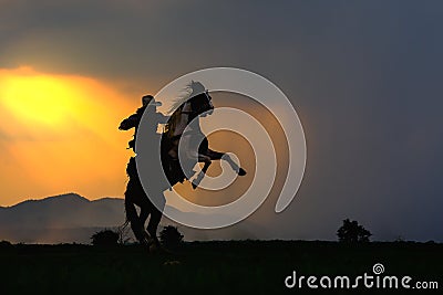 Cowboy silhouette on horse during nice sunset Stock Photo