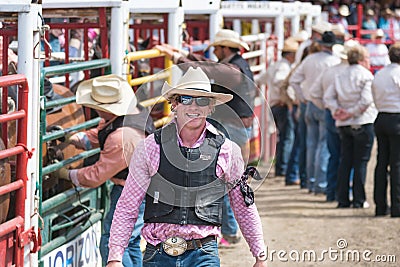 Cowboy smiles for press as he walks by the chutes at the Williams Lake Stampede Editorial Stock Photo