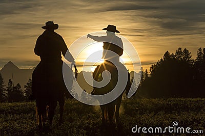 Cowboys riding across grassland early moring, British Colombia, Stock Photo