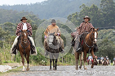 Cowboys in traditional wear riding in the Andes of Ecuador Editorial Stock Photo