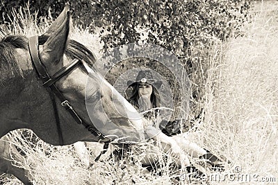 Cowboy, Cowgirl country and western couple with horse and saddle on ranch Stock Photo