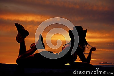 Cowgirl lay stomach silhouette Stock Photo