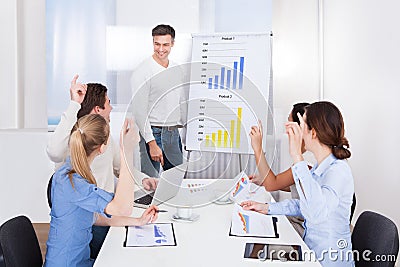 Coworkers asking queries to team leader Stock Photo