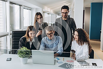 Coworkers looking at a computer and talking about work Stock Photo