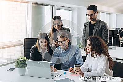 Coworkers looking at a computer and talking about work Stock Photo