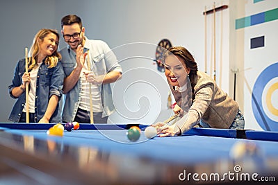 Coworkers playing a game pool after a long work day Stock Photo