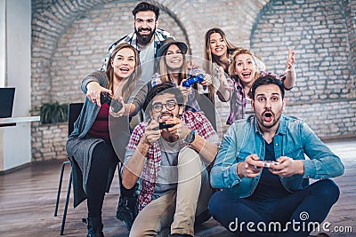 Coworkers playing video games in office. Stock Photo